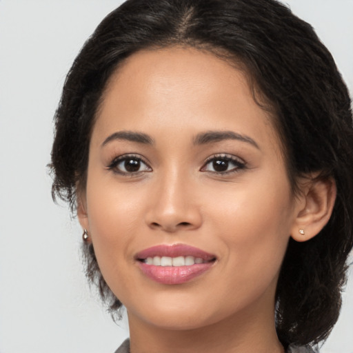 Joyful latino young-adult female with long  brown hair and brown eyes