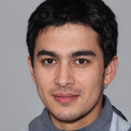 Joyful white young-adult male with short  black hair and brown eyes