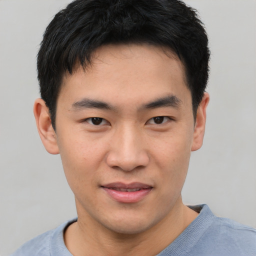 Joyful asian young-adult male with short  black hair and brown eyes