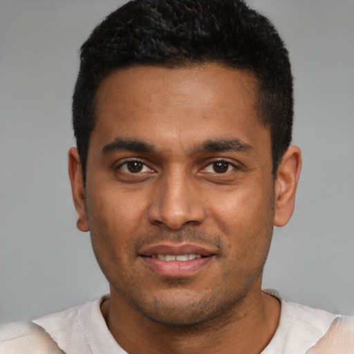 Joyful black young-adult male with short  black hair and brown eyes