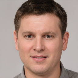 Joyful white young-adult male with short  brown hair and grey eyes