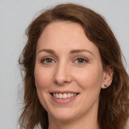 Joyful white young-adult female with long  brown hair and green eyes