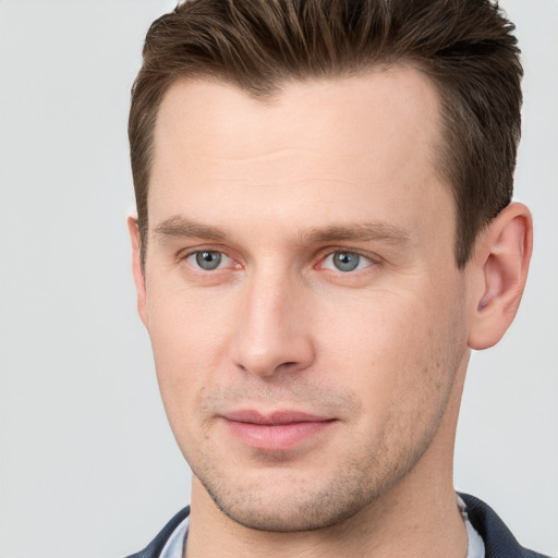 Joyful white young-adult male with short  brown hair and grey eyes