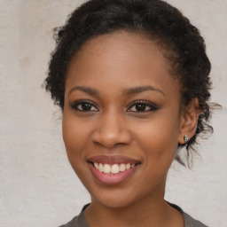 Joyful black young-adult female with long  brown hair and brown eyes