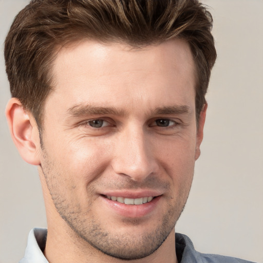 Joyful white young-adult male with short  brown hair and grey eyes