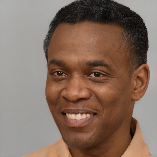 Joyful black adult male with short  black hair and brown eyes