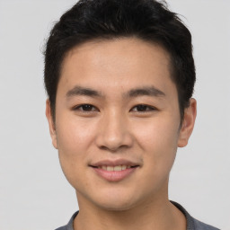 Joyful asian young-adult male with short  brown hair and brown eyes