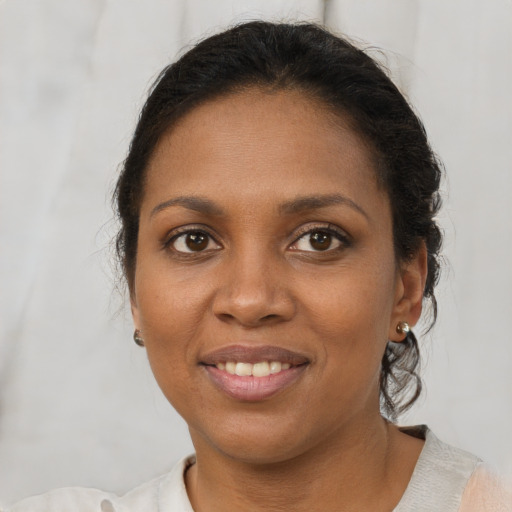 Joyful black young-adult female with short  brown hair and brown eyes