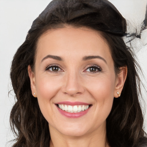 Joyful white adult female with long  brown hair and brown eyes