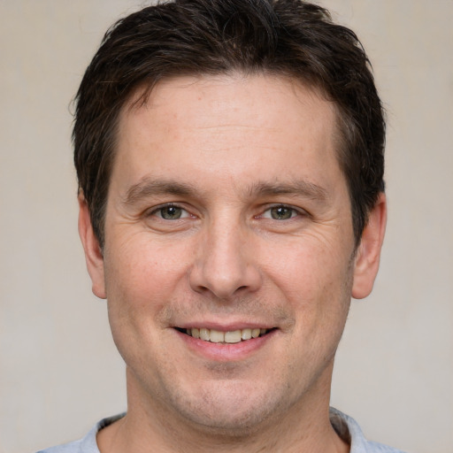 Joyful white adult male with short  brown hair and grey eyes