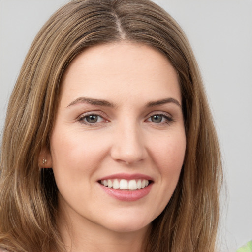 Joyful white young-adult female with long  brown hair and green eyes