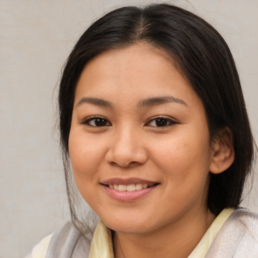 Joyful latino young-adult female with medium  brown hair and brown eyes