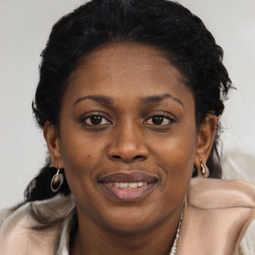 Joyful black adult female with short  black hair and brown eyes