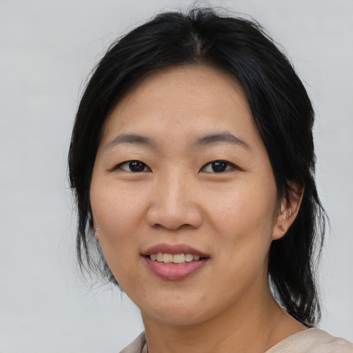Joyful asian young-adult female with medium  black hair and brown eyes