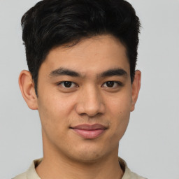 Joyful asian young-adult male with short  brown hair and brown eyes