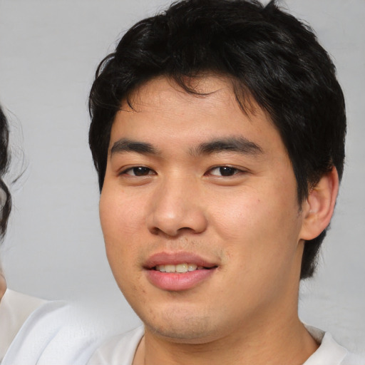 Joyful asian young-adult male with medium  brown hair and brown eyes