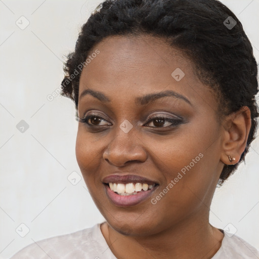 Joyful black young-adult female with short  black hair and brown eyes