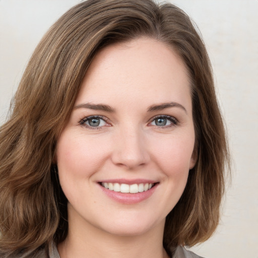 Joyful white young-adult female with medium  brown hair and green eyes