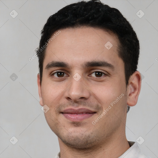 Joyful white young-adult male with short  black hair and brown eyes