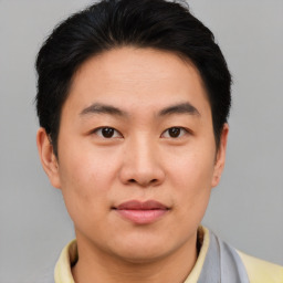 Joyful asian young-adult male with short  brown hair and brown eyes