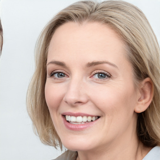 Joyful white young-adult female with medium  brown hair and blue eyes