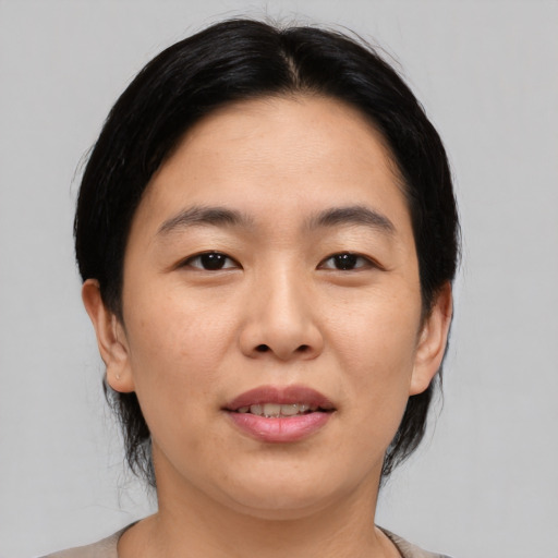 Joyful asian young-adult female with medium  black hair and brown eyes