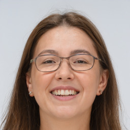 Joyful white adult female with long  brown hair and grey eyes