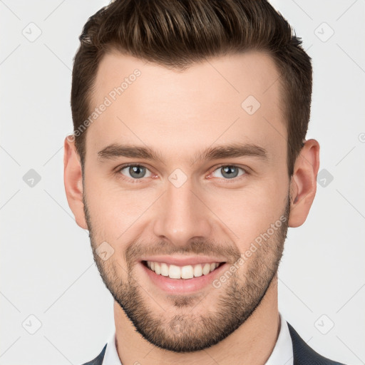 Joyful white young-adult male with short  brown hair and grey eyes