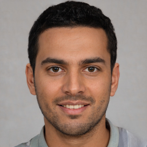 Joyful white young-adult male with short  black hair and brown eyes
