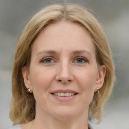 Joyful white adult female with medium  brown hair and blue eyes