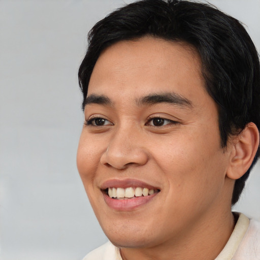 Joyful asian young-adult male with short  black hair and brown eyes