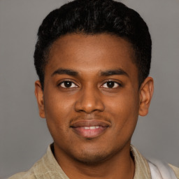 Joyful black young-adult male with short  brown hair and brown eyes