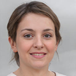 Joyful white young-adult female with medium  brown hair and grey eyes