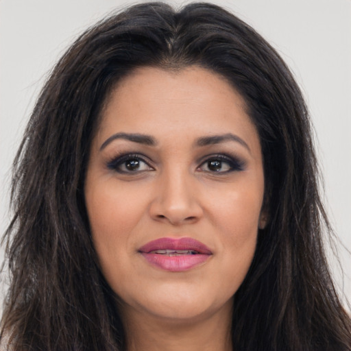 Joyful latino young-adult female with long  brown hair and brown eyes