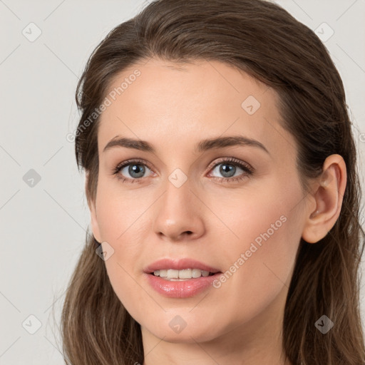 Joyful white young-adult female with long  brown hair and grey eyes