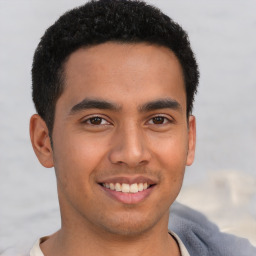 Joyful latino young-adult male with short  brown hair and brown eyes