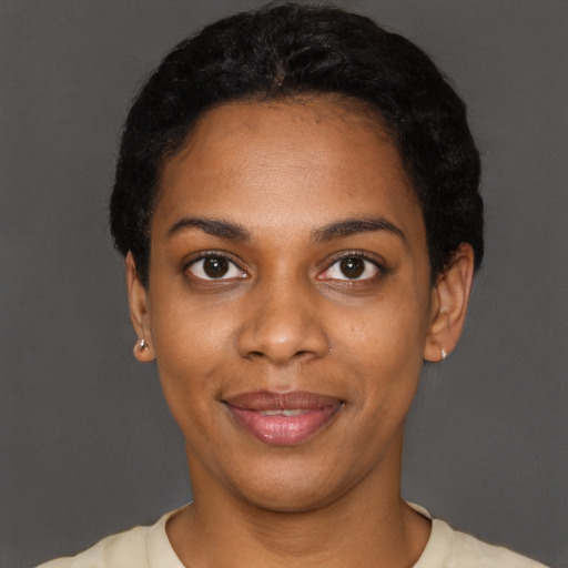 Joyful black young-adult female with short  black hair and brown eyes
