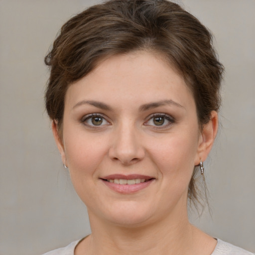 Joyful white young-adult female with medium  brown hair and green eyes