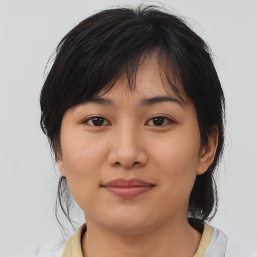 Joyful asian adult female with medium  brown hair and brown eyes