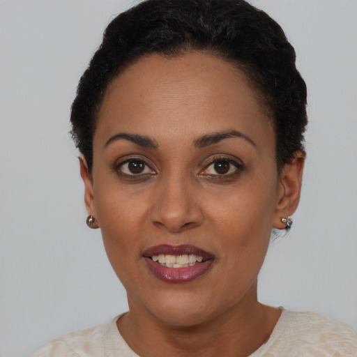 Joyful black young-adult female with short  black hair and brown eyes