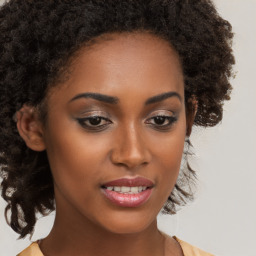 Joyful black young-adult female with long  brown hair and brown eyes