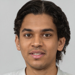 Joyful latino young-adult male with short  brown hair and brown eyes