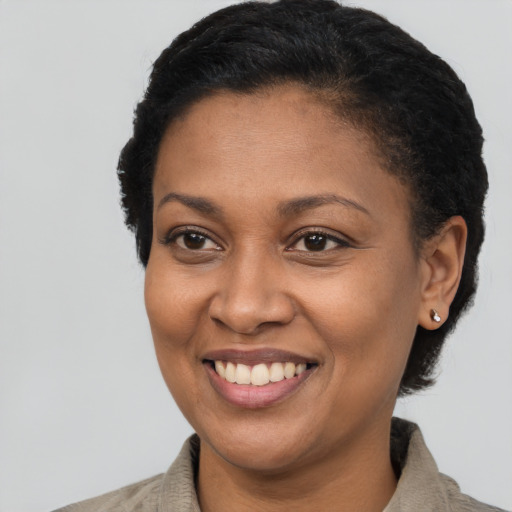 Joyful black young-adult female with short  black hair and brown eyes