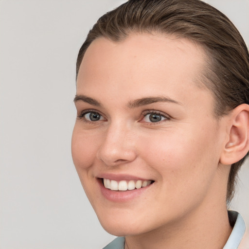 Joyful white young-adult female with short  brown hair and grey eyes