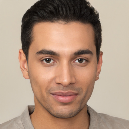 Joyful latino young-adult male with short  brown hair and brown eyes