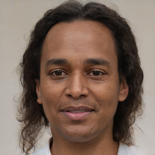 Joyful latino adult male with medium  brown hair and brown eyes