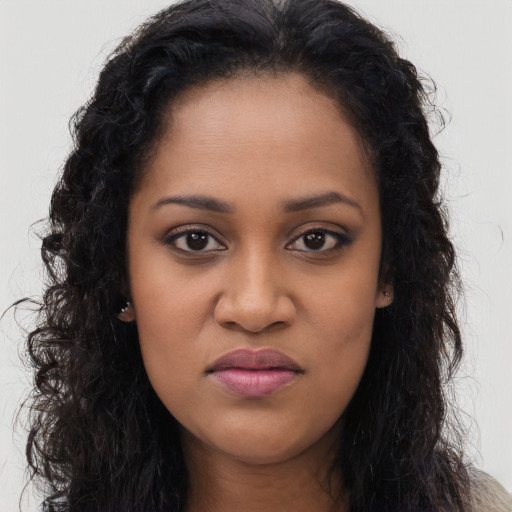 Joyful black young-adult female with long  brown hair and brown eyes