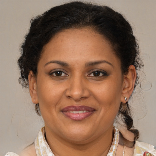 Joyful latino adult female with medium  brown hair and brown eyes