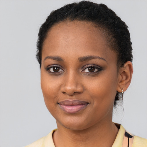 Joyful black young-adult female with short  black hair and brown eyes