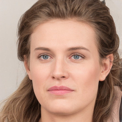 Joyful white young-adult female with long  brown hair and grey eyes